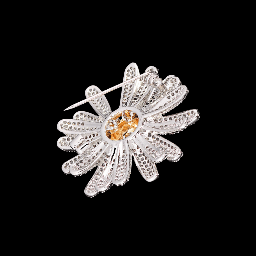 AVELIA silver sunflower brooch featuring fully paved crystal petals and a textured gold center on a black background.