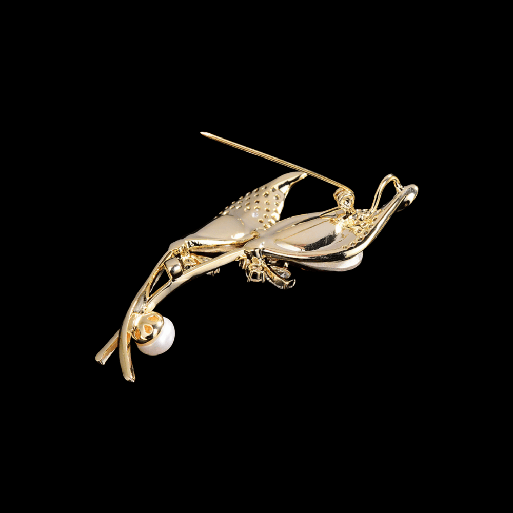 AVELIA gold double calla lily brooch featuring two large purple teardrop crystals, petal edges, and a white pearl accent on a black background.